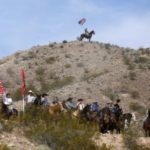 Protesters on horseback ride on the hills above a rally site in Bunkerville, Nevada